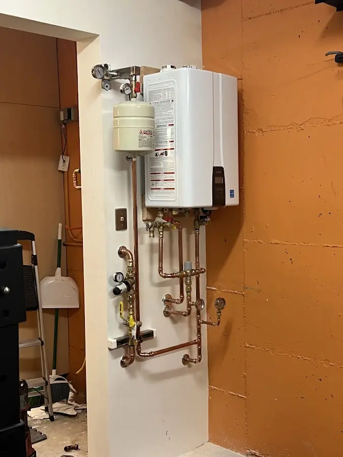 Plumbing technician inspecting water heater connections in Bluefield